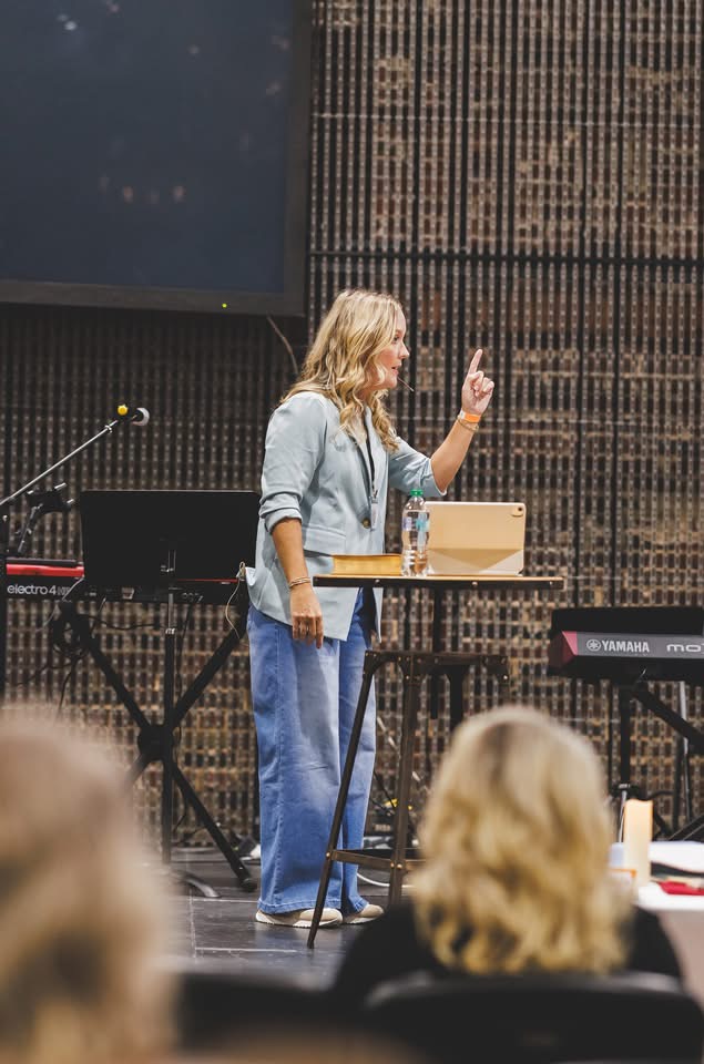 Shea Pirtle speaking at a conference, pointing upward
